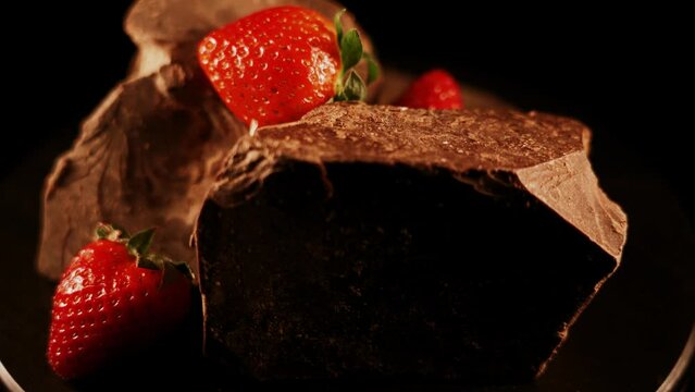 Red straberry with a dark chocolate on a black background 4k