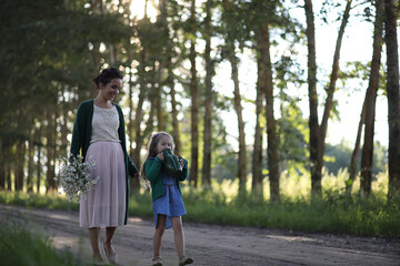 Fototapeta premium Mother with daughter walking on a road