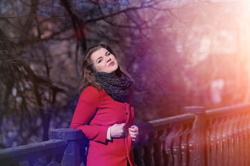 Obraz na płótnie Canvas Pretty girl on a walk in red coat in the city