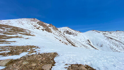 Snow-capped spring mountains. Beautiful mountain landscape. The amazing nature of Kyrgyzstan. Blue sky.