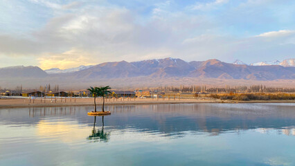 Stunning sunset on Lake Issyk-Kul, Kyrgyzstan. The calm surface of the water. Beautiful mountain...