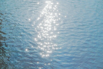 Sun glare on the water. Blue water summer background.