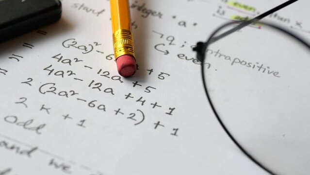 Hand writing algebra equations on a paper 