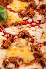 Closeup on huge pizza with cheddar cheese and minced beef