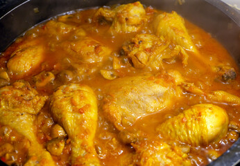 Pollo estofado cocinándose en una cazuela.