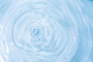 	
Blue drops of water dripping into the water with ripples and waves in the background.	
