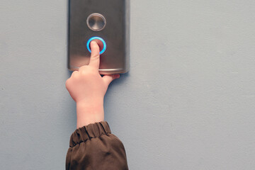 A small child presses the elevator call button. Baby reaches for the elevator button in a...