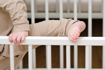 Baby escapes from the crib by climbing over the bars. The child climbs over the railing bed. Kid...