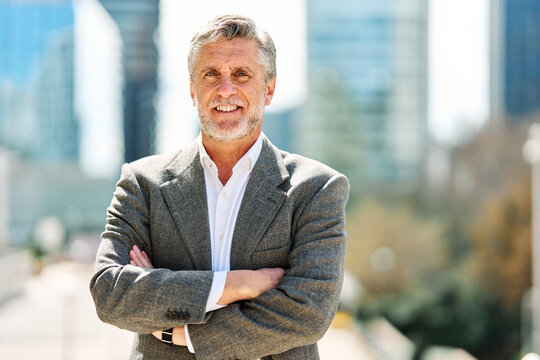 Businessman with grey hair and formal wear smiling at camera