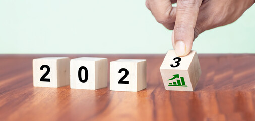 Business growth concept in 2023. Business goals and achievement. Sustainable development. Wooden cubes inscripted 2023 and growth icon on smart background. Positive indicators banner
