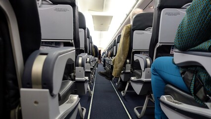 The interior aisle and seating of an airliner.