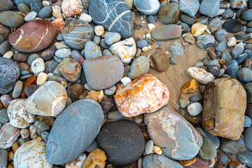 .amazing to see on the beach is full of round rocks instead of sand. .round rocks have beautiful color and various size. .rocks beach at the lighthouse landmark of Lanta island Krabi. stone background