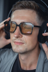 Young handsome man make selfie on smartphone, happy face, outdoor hipster portrait on home, smile happy face, listen music on headphones, Amsterdam house dance, player,photo concept, glasses, kimono