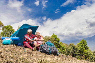 Senior friends enjoying quality time together during camping on mountain.