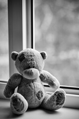 Children toy teddy bear edge open window.Concept of accidents with children.
