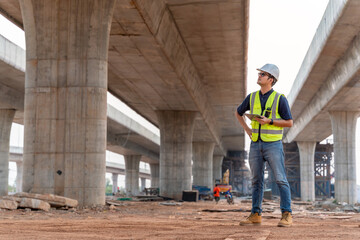 A civil engineer is inspecting a road or expressway construction project under a road under construction.