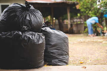 The big black garbage bag placed on the floor.