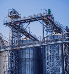 Modern silos for storing grain harvest at the blue sky background. 