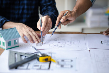 The home design architects are reviewing the house plan draft, the project commissioned by the client, and the custom design before delivery. Interior design and decoration ideas.