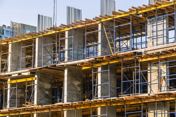 A frame made of load-bearing reinforced concrete walls during the construction of a multi-storey building. Reinforcement of reinforced concrete columns. Construction of high-rise buildings.