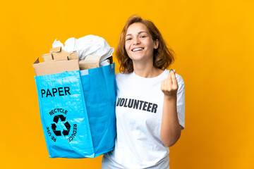 Young Georgian girl holding a recycling bag full of paper to recycle making money gesture