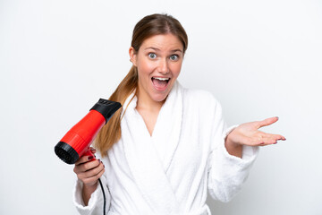 Young caucasian woman holding hairdryer isolated on white background with shocked facial expression