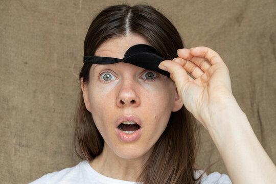 The girl opened the bandage from one eye and made a surprised face, the emotion of surprise from what she saw, the bandage on one eye, look