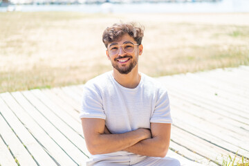 Handsome Arab man at outdoors With glasses with happy expression