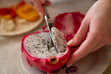 Carving out dragon fruit (pitahaya) with a knife