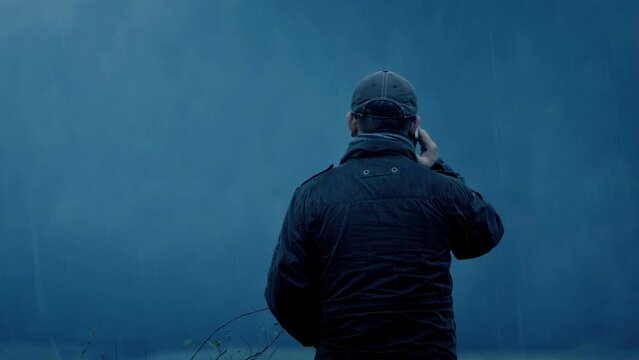 Man Talks On Phone Outdoors In The Rain