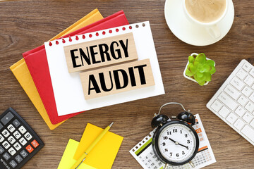 Energy Audit. two wooden blocks with text on on the working table near the stationery