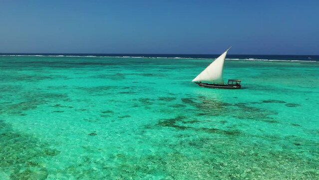 Sailboat in the ocean. Sunset. Drone view of the african traditional wooden boats. Sailing yachts moored off the coast of the Indian Ocean near Zanzibar island at sunset. Romantic atmosphere.