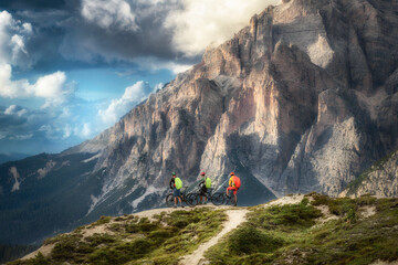 Friends mountain biking enthusiasts take a break, enjoy beautiful landscape, group of people on...