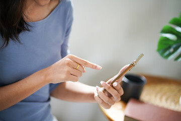 Obraz na płótnie Canvas Asian Business woman using smart phone spending time checking news social media cell telephone technology e-commerce .