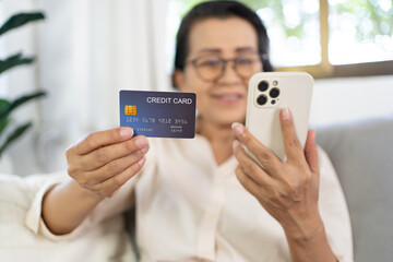 Senior woman with smart phone for online shopping.  Hand holding mobile phone with Payment on credit card online shopping electronic wallet Payment Shopping by phone and connected card concept