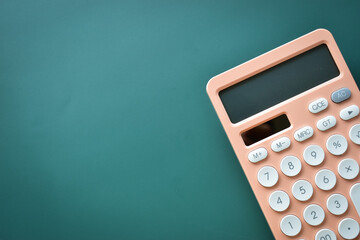 modern peach colour pastel calculator and white button on green background, business and finance accounting concept