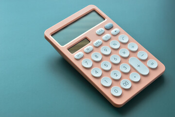 modern peach colour pastel calculator and white button on green background, business and finance...