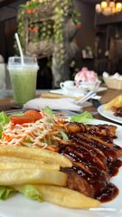 Steak with fried potatoes and salad with drinks