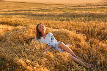 Naklejka na ściany i meble girls in a wheat field at sunset. Ukraine . Family walk in the field, wheat field, sunset in the field, girl in vyshyvanka in the field