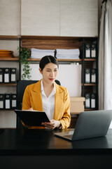 Business woman using tablet and laptop for doing math finance on an office desk, tax, report,...