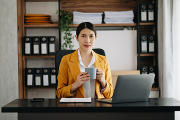 Business woman using tablet and laptop for doing math finance on an office desk, tax, report, accounting, statistics, and analytical research concept in office.