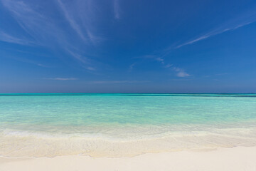 Empty tropical island beach seascape horizon. Closeup of sand waves splash under blue summer sky....