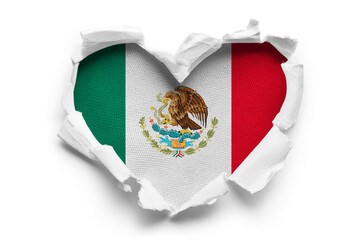 Heart shaped hole torn through paper, showing satin texture of flag of Mexico, cut out