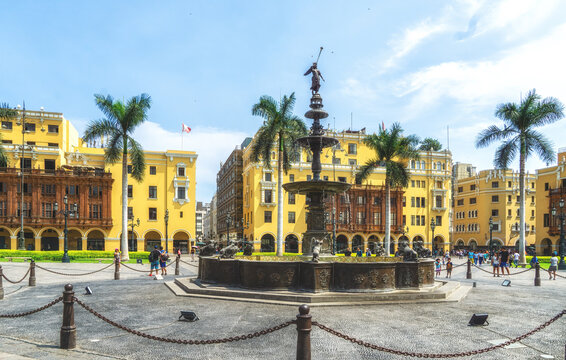 Bronze fountain and yellow colonial buildings at Plaza de Armas or Plaza Mayor