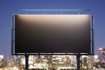 Blank black horizontal billboard on city buildings background at night, front view. Mockup, advertising concept