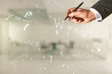 Man hand with pen working with scientific formula hologram on blurred classroom background, research concept. Multiexposure