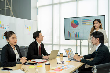 Business people discussing company presentation at boardroom table.