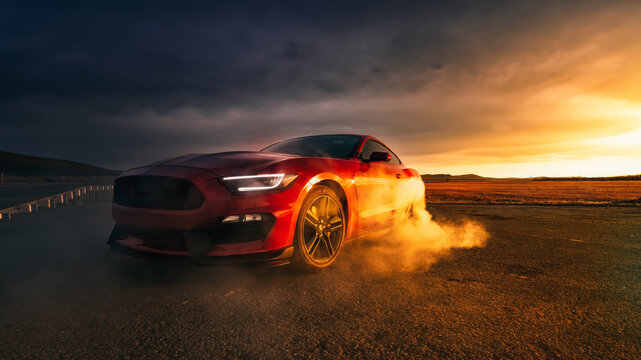 LA, California - April 30, 2023 Ford Mustang red at sunset smoke from under the wheels. American muscle car