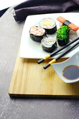 Sushi served in a white plate with sauce.