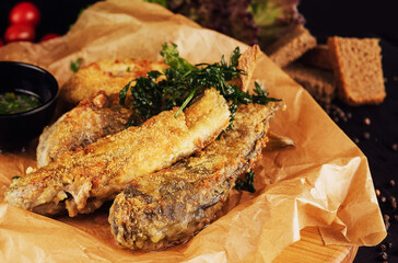 fried fish with garlic sauce on a cutting board